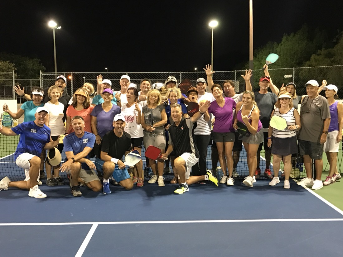 A full camp group celebrating on court at night
